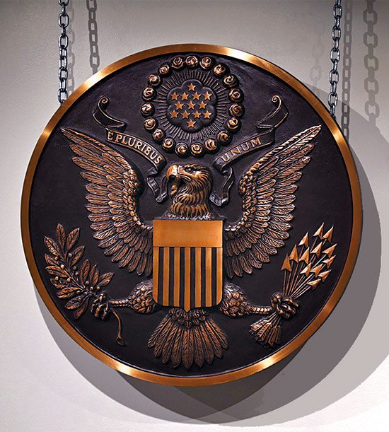 Seal of the U.S.A. on a copper, circular plaque.