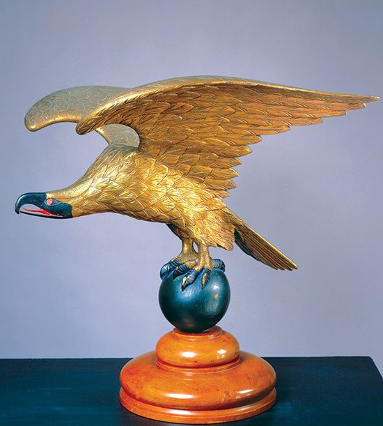 A sculpture of a gold eagle spreading its wings.